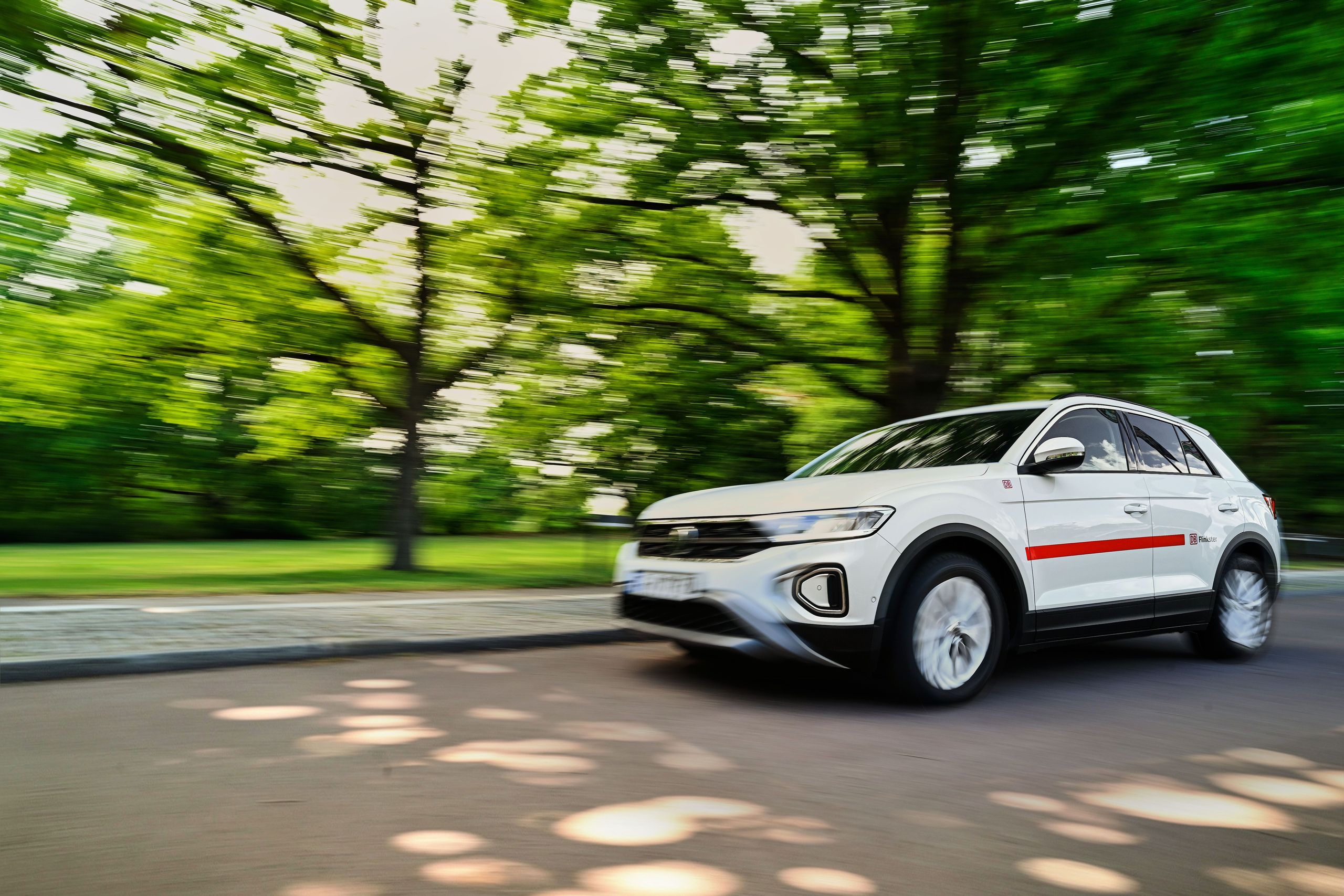 Flinkster VW T-Roc fährt von rechts nach links in der Abendsonne