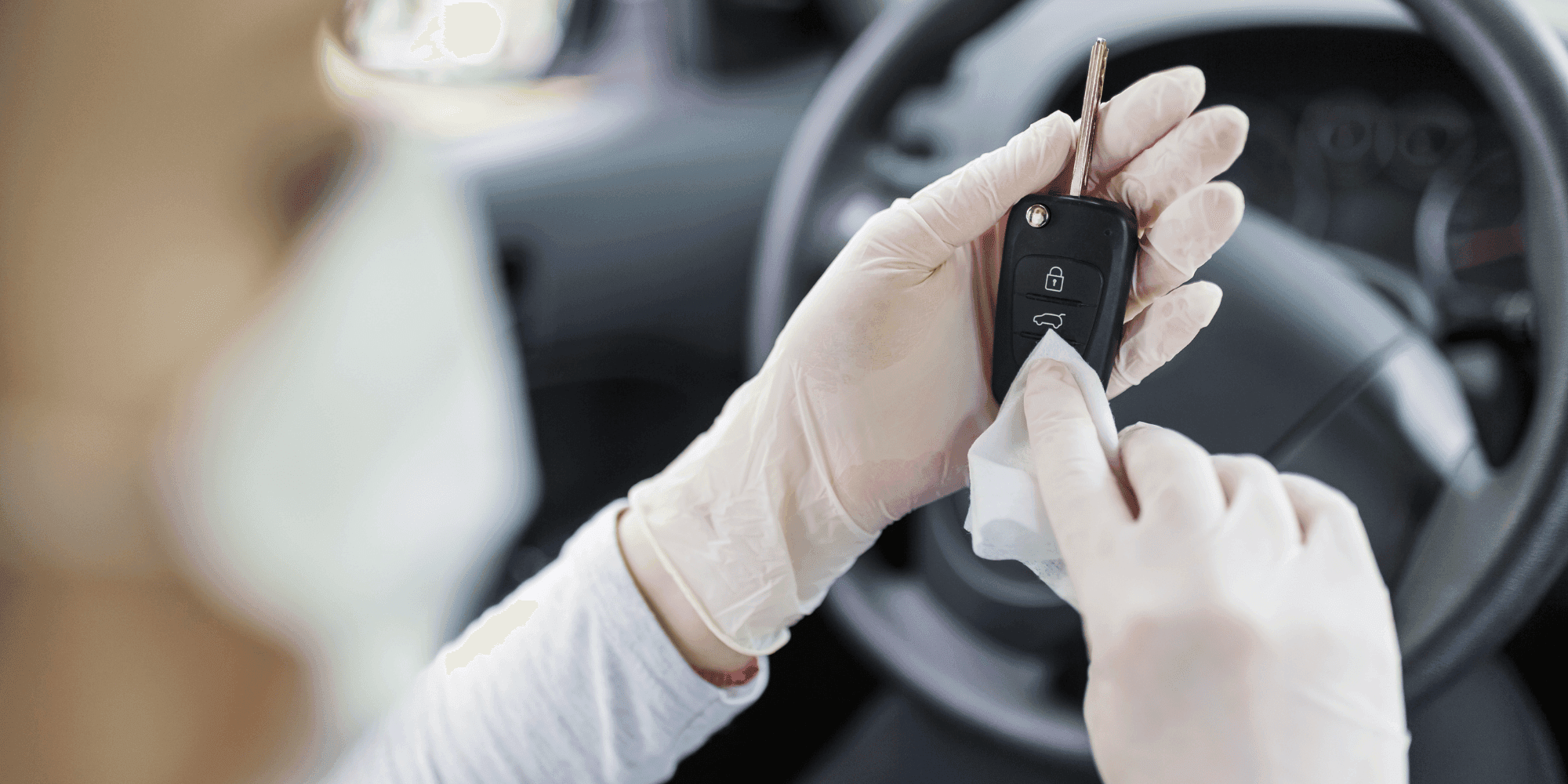 Person mit Handschuhen desinfiziert einen Autoschlüssel im Innenraum eines Autos. copyright Foto: istock.com/zoff-photo