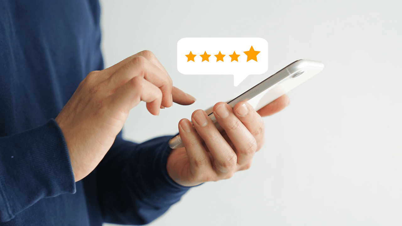 Mann mit blauem Hemd tippt auf weißem Smartphone eine top 5 Sterne Bewertung ein copyright Foto: istock.com/Chainarong Prasertthai